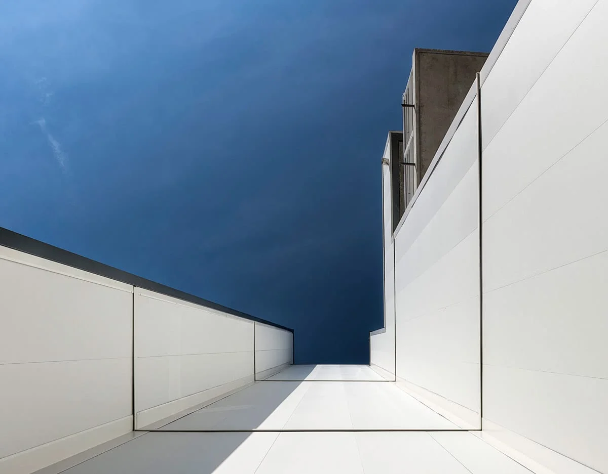 Perspective architecturale minimaliste, façades blanches et ciel bleu – photographie d’architecture contemporaine Lille 2025