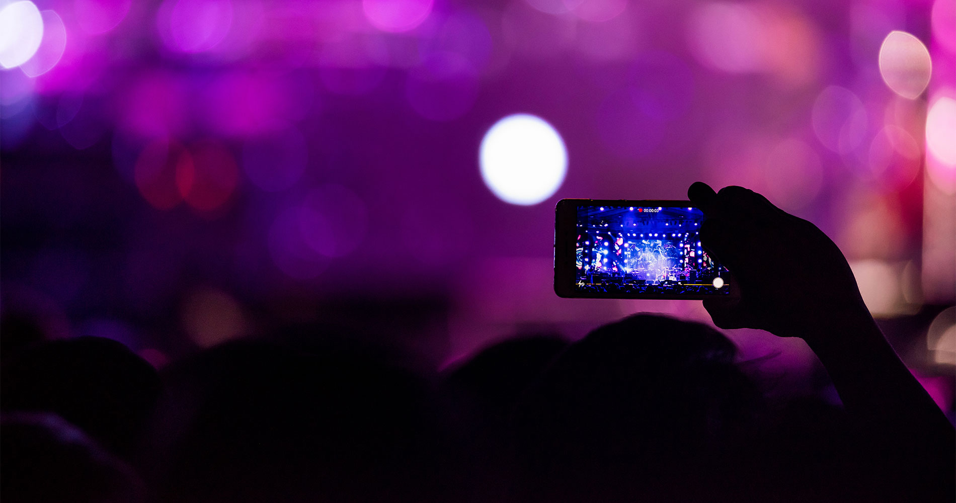 Crowd member filming concert