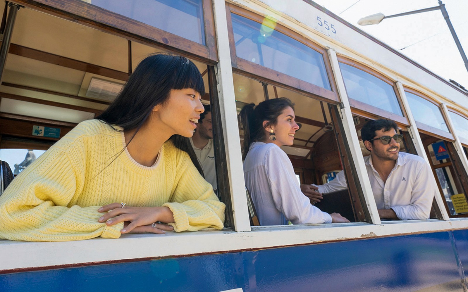 Orang-orang menikmati perjalanan dengan trem bersejarah di kota tua Lisbon.