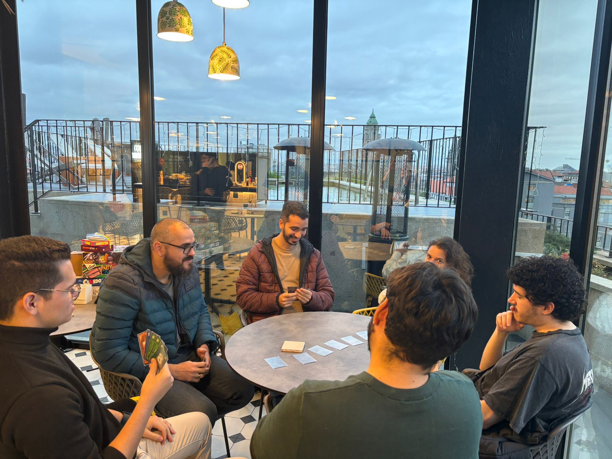 Five man and a woman playing board games during a team meeting.