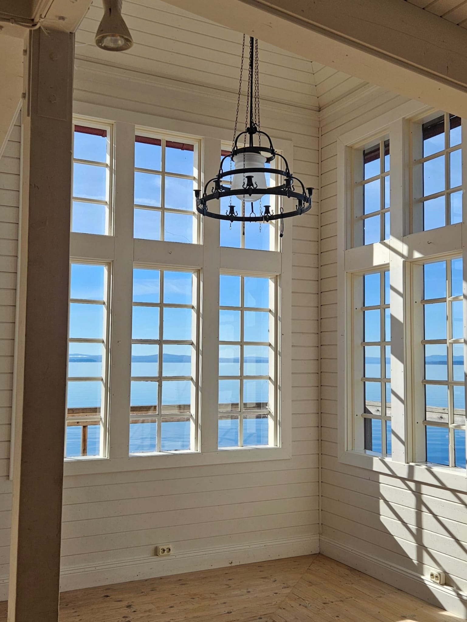 A serene pathway lined with trees leads to a distant building, bathed in warm sunlight.