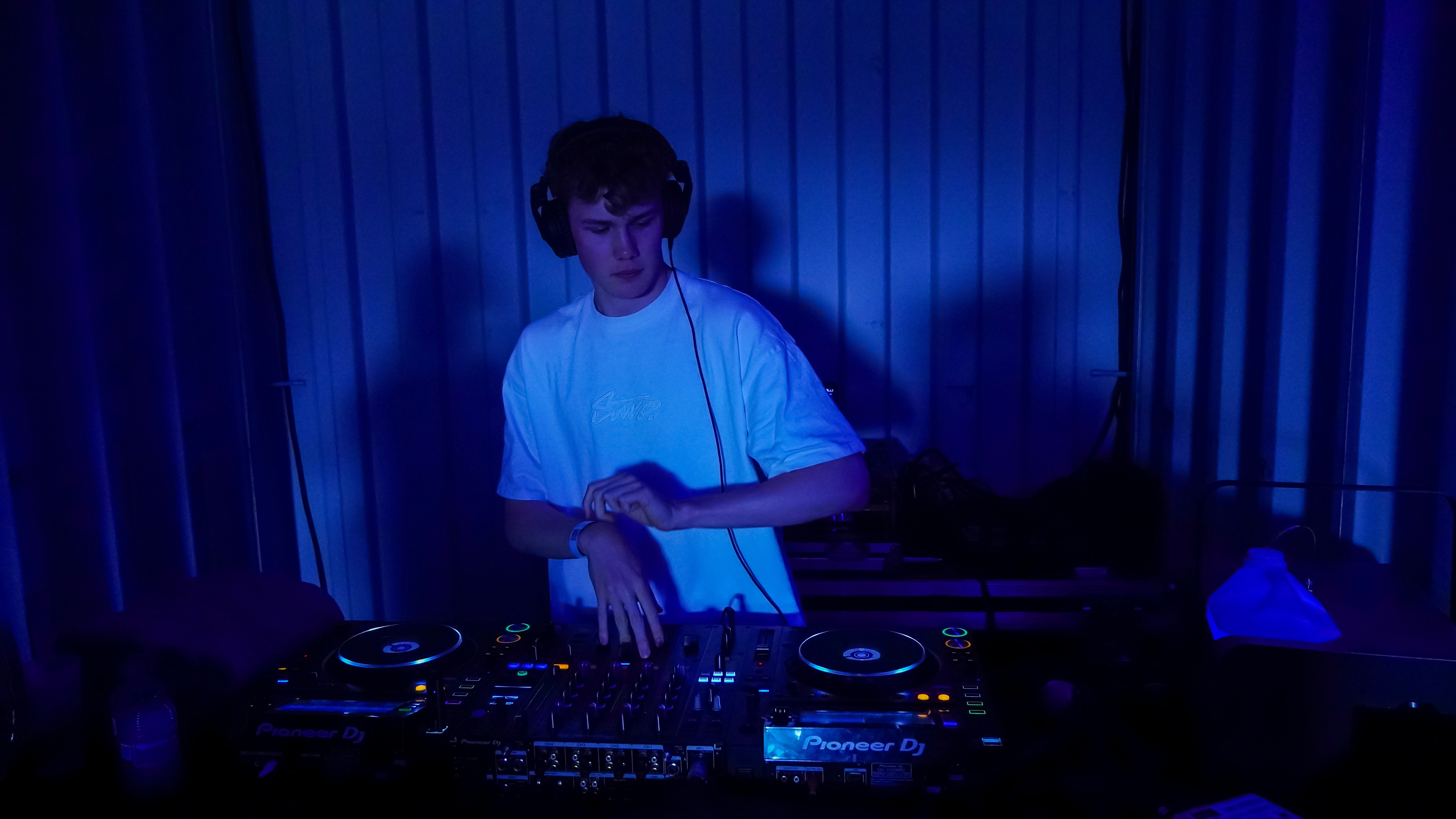 Domini DJing live under blue stage lighting
