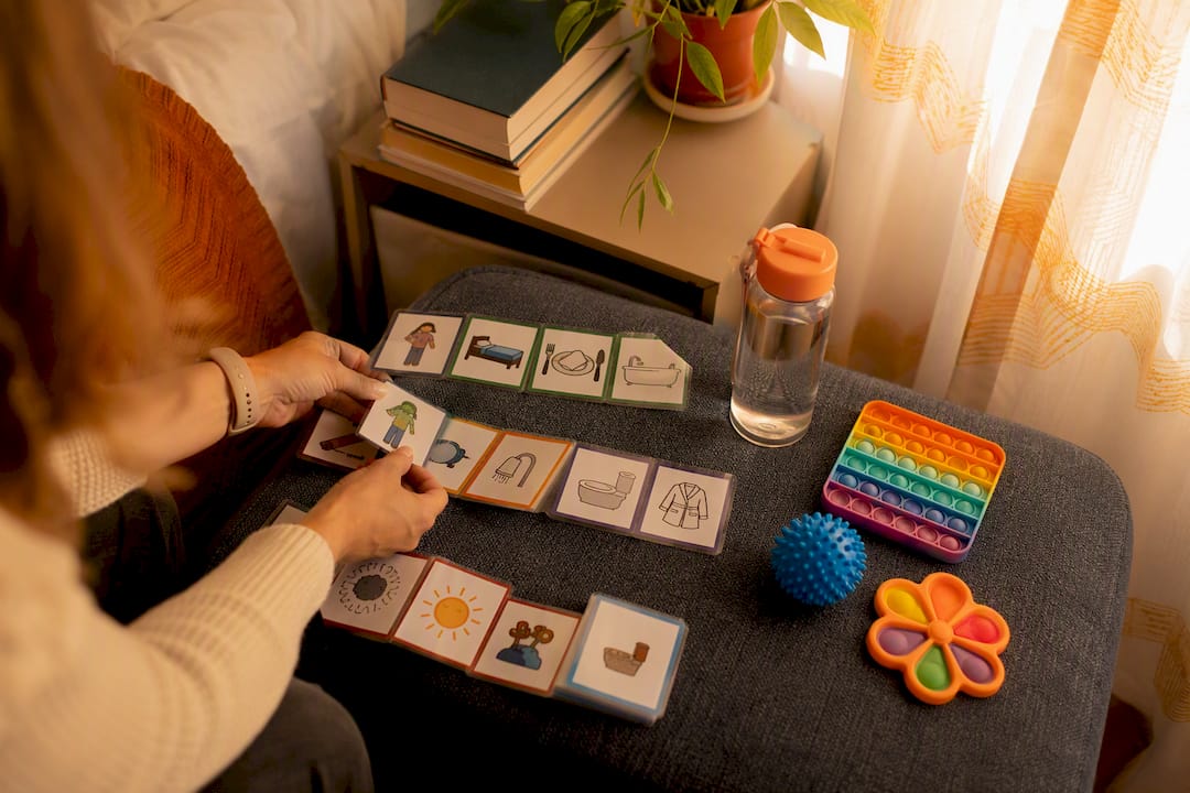 Caregiver hands holding picture communication cards