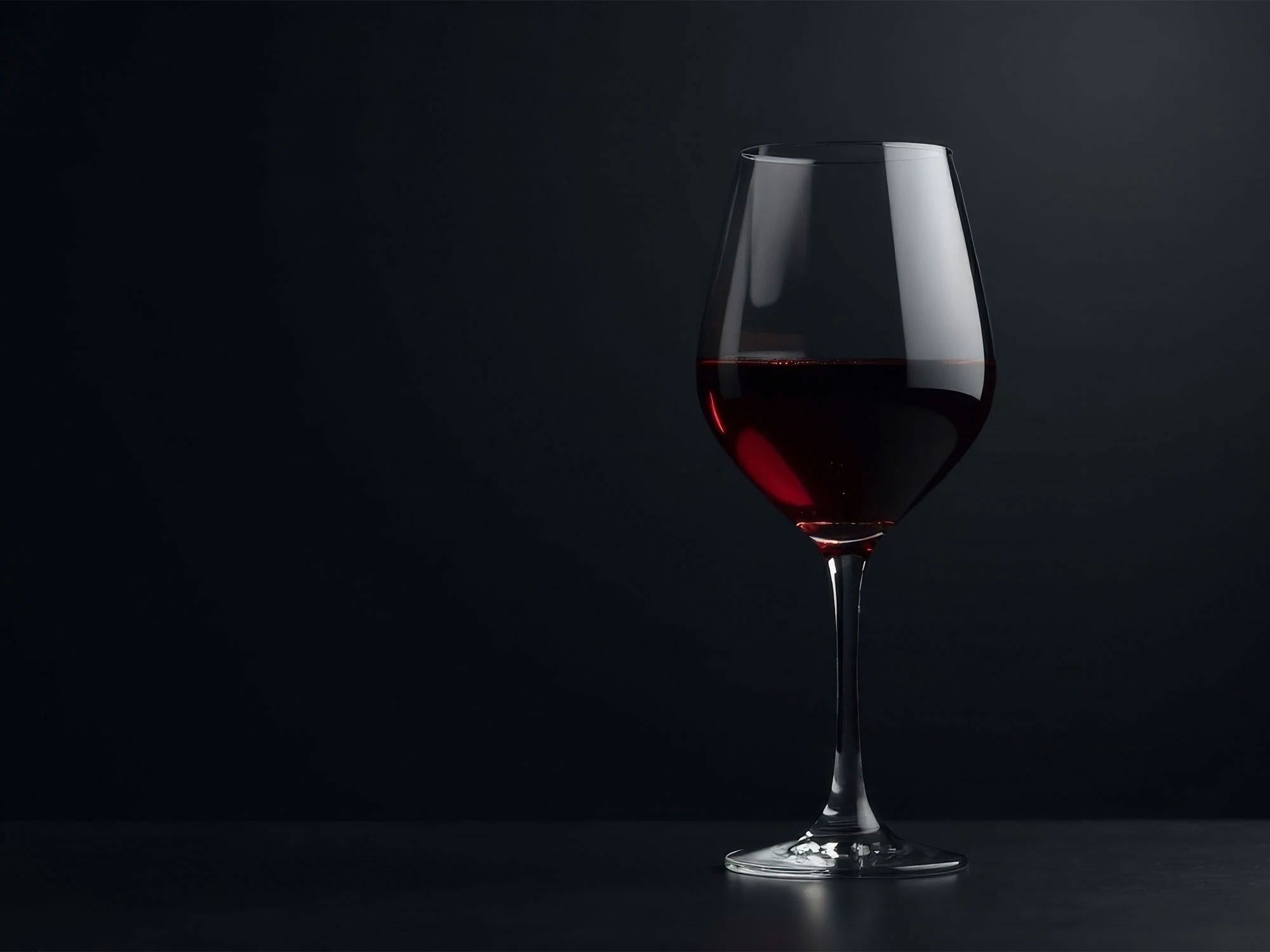 Studio Odeia, verre de vin rouge sur fond noir.