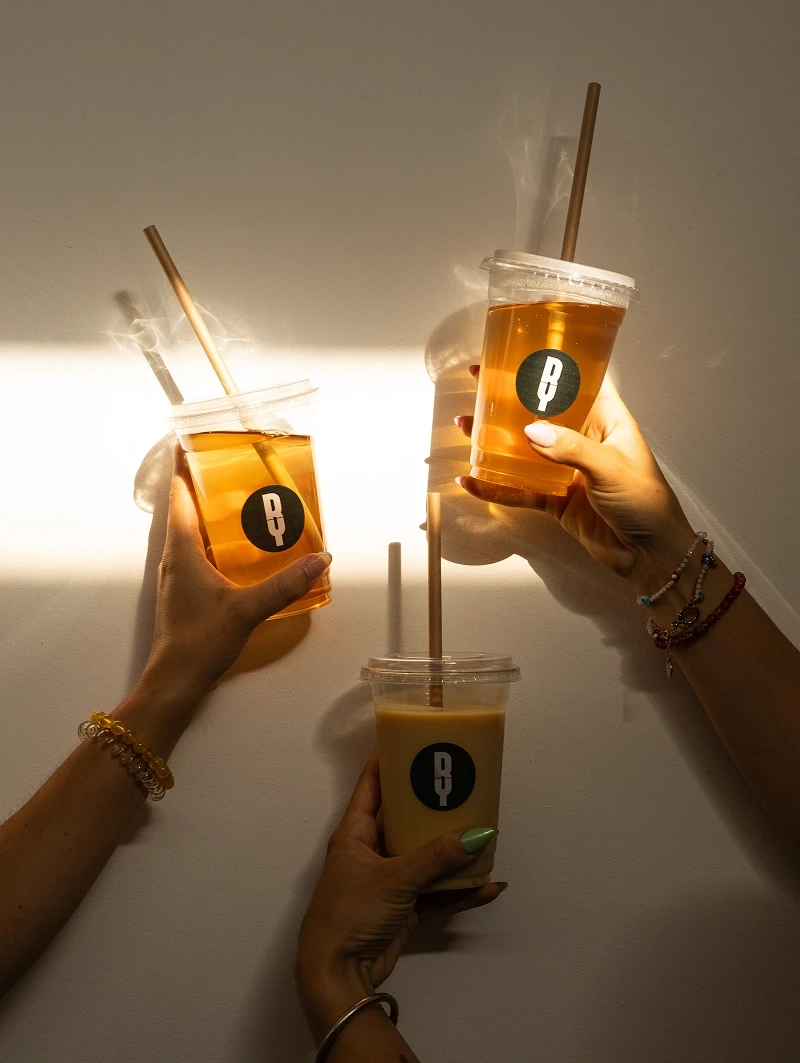 Trois boissons du Wellness Center sont tenues à la main dans un jeu de lumière