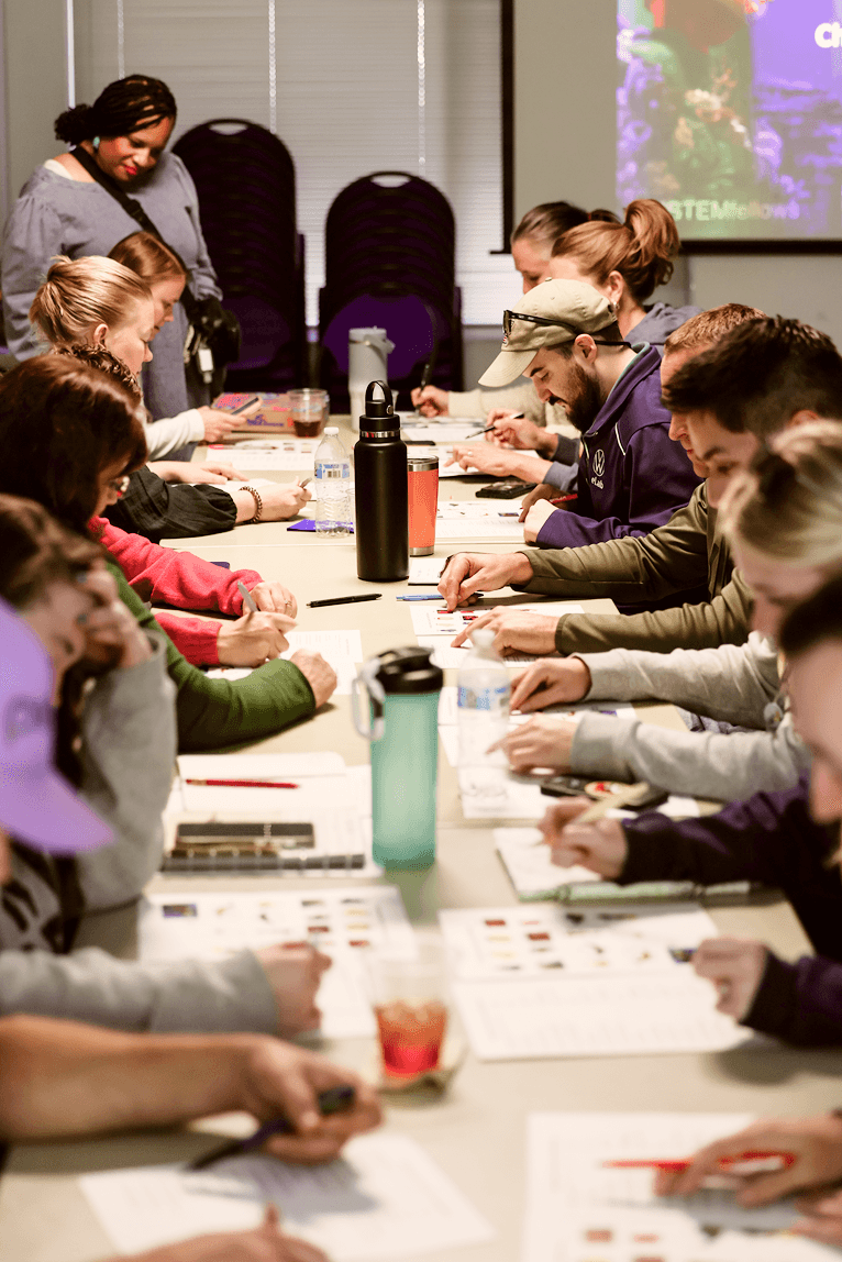 A group of educators sitting around a table, designing a project.