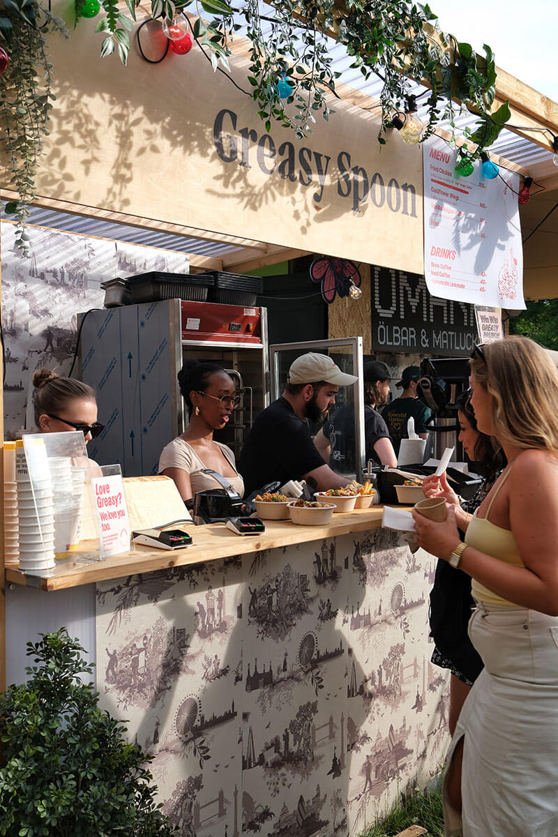 Employees handing out food to customers behind the bar
