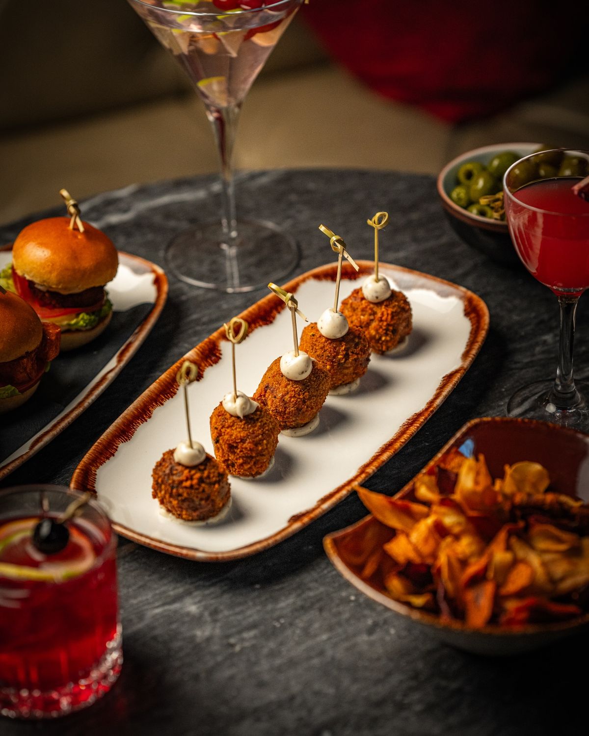 Elegant Indian fusion appetizers served with craft cocktails at Dhoom, showcasing modern Indian small plates in a luxury Toronto dining setting.