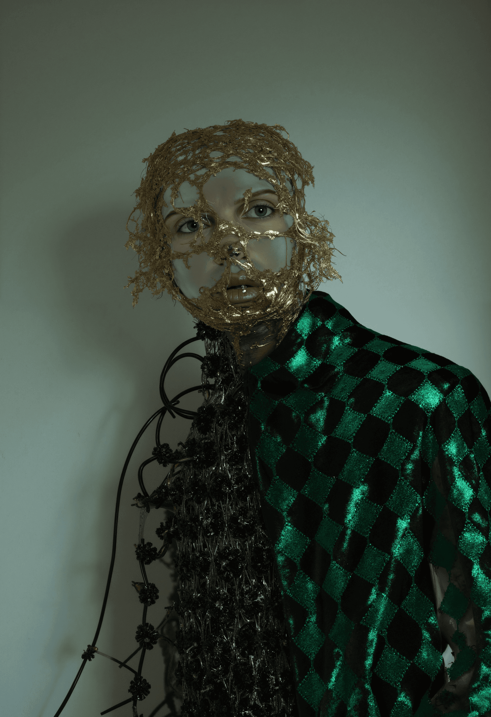 Fashion photo. Man in green jacket and golden face wires.