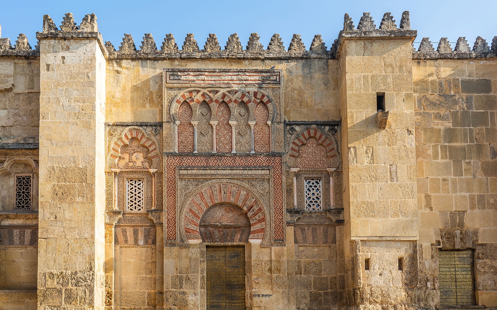 Mezquita-Catedral de Córdoba con una pared exterior ornamentada con arcos y intricada cantería.