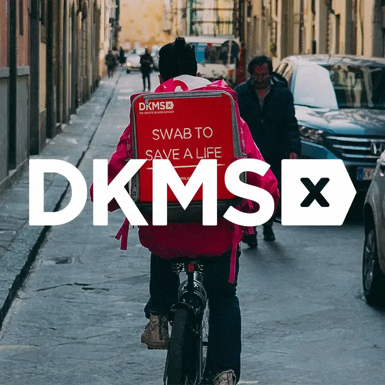 DKMS volunteer cycling in London with Swab to Save a Life backpack - We Delete Blood Cancer campaign