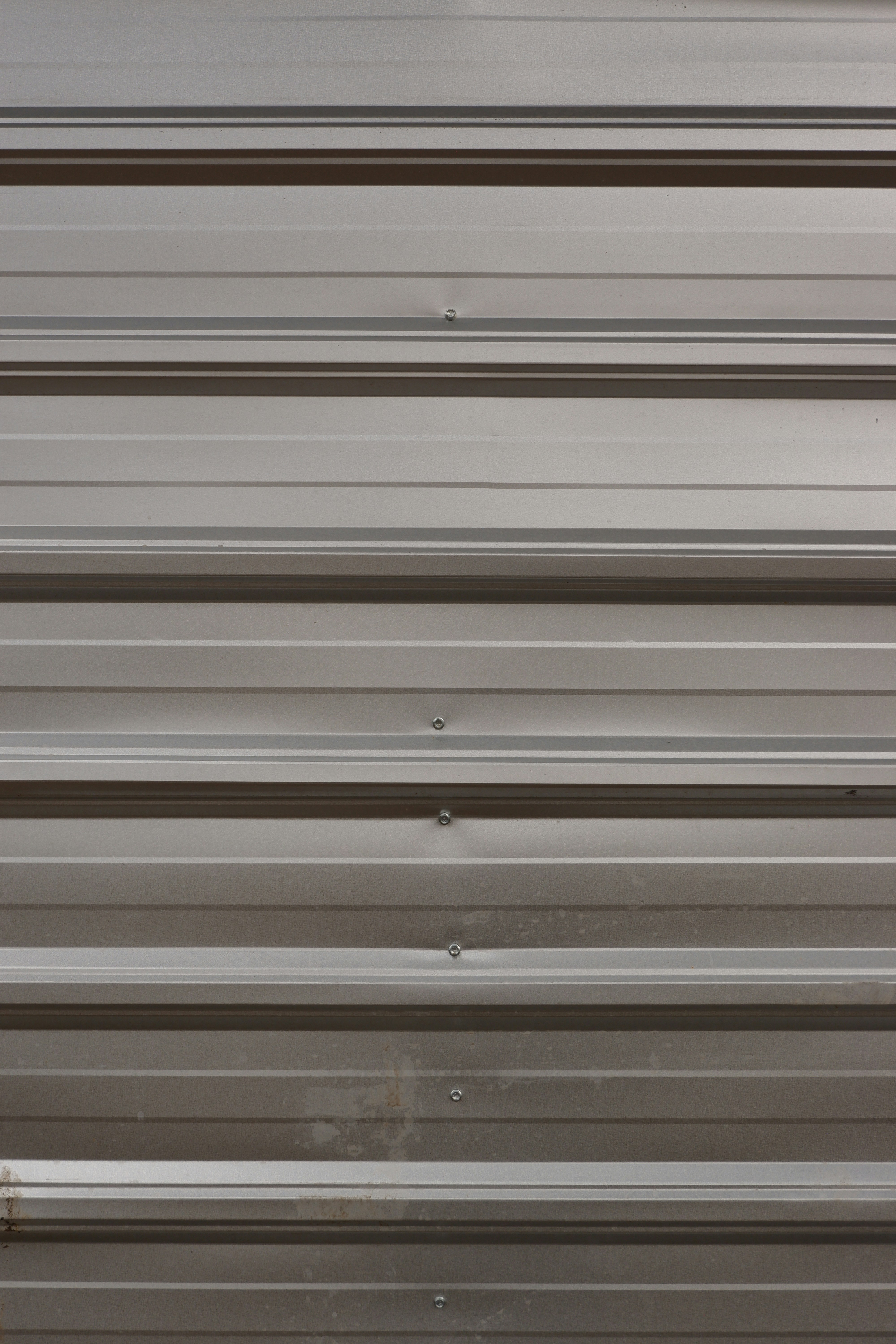 A close up of a metal door with a red handle