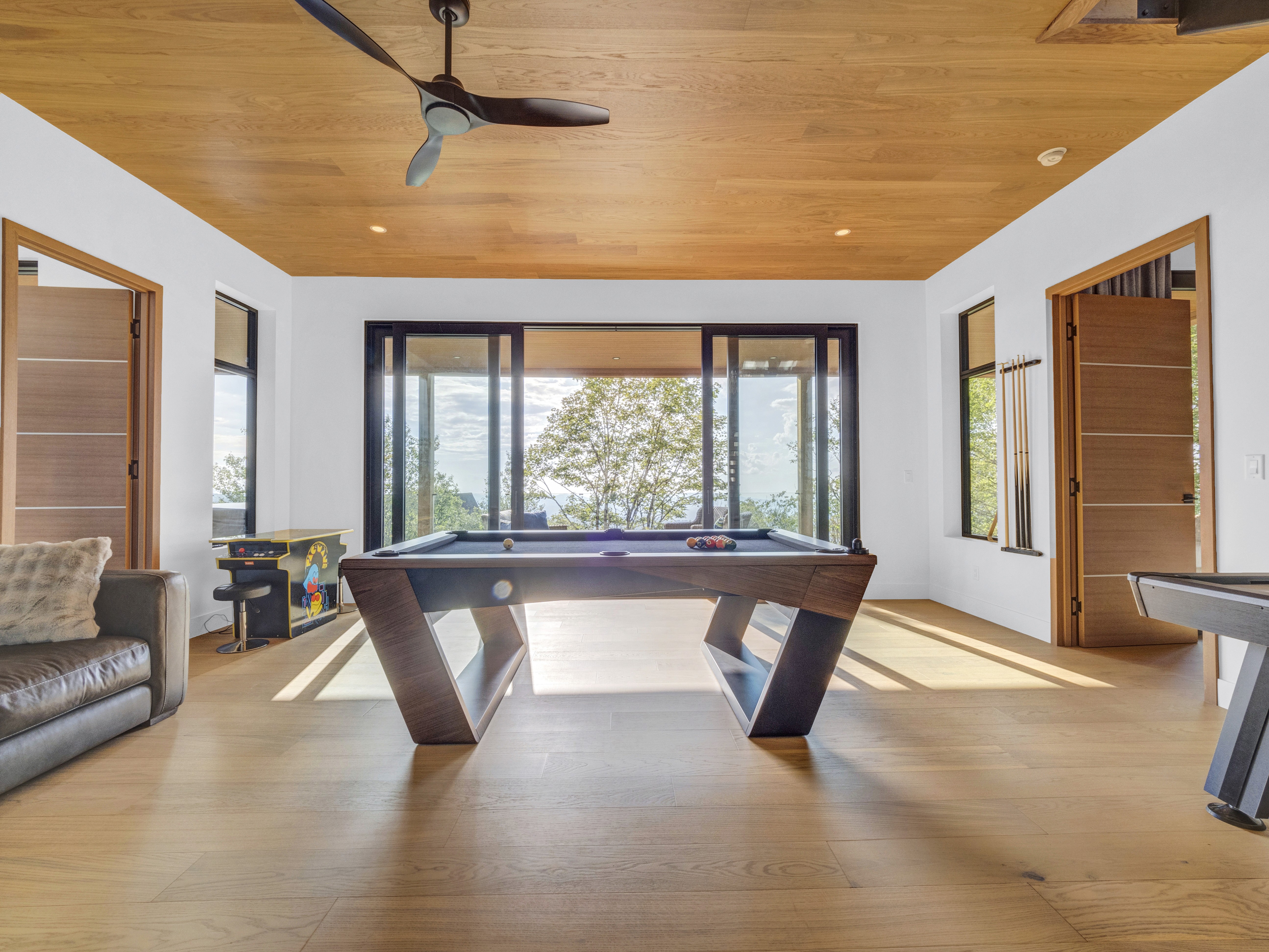 a wide game room view with huge windows to mountain views