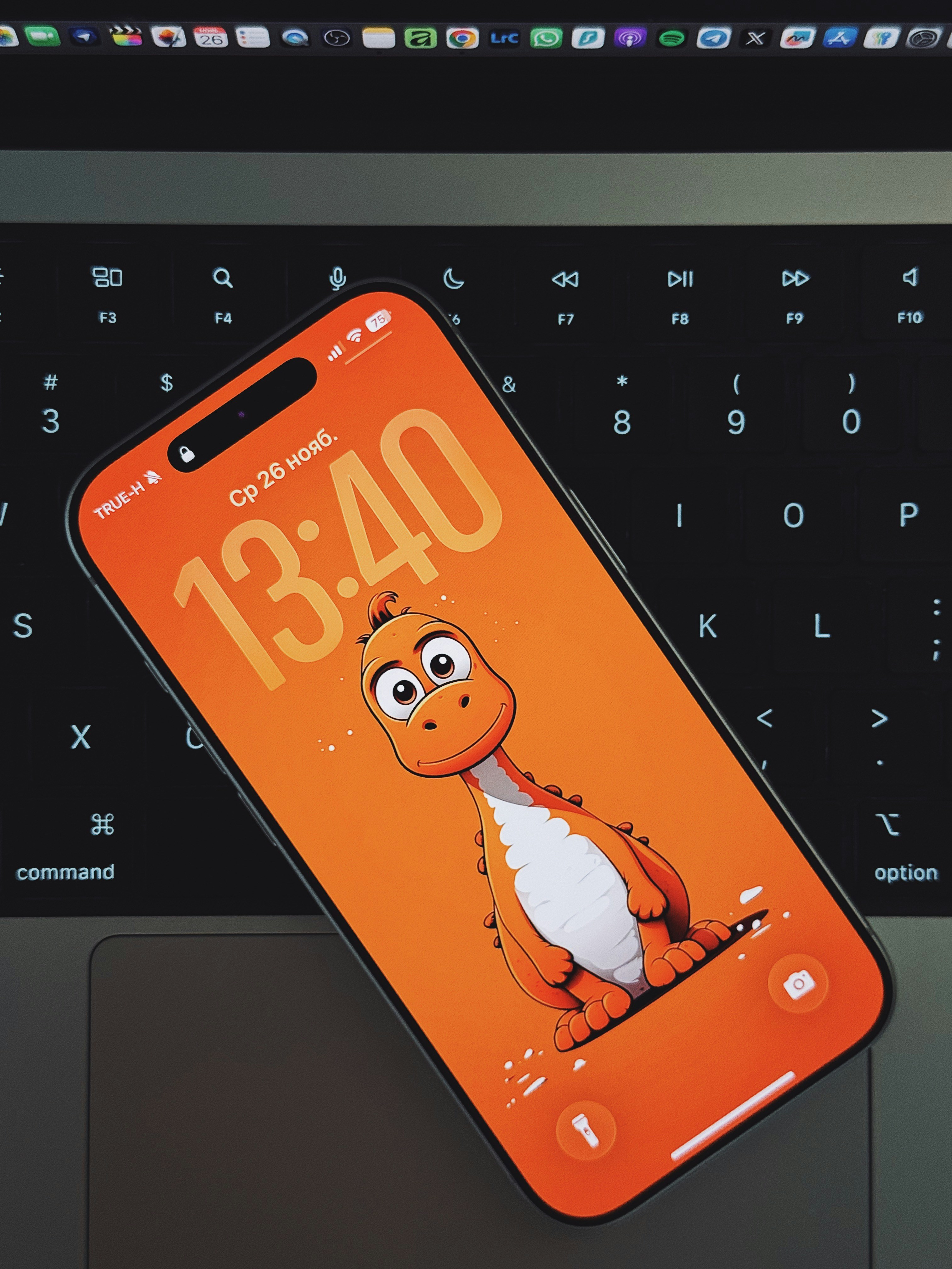 Smartphone with cartoon dinosaur wallpaper on keyboard
