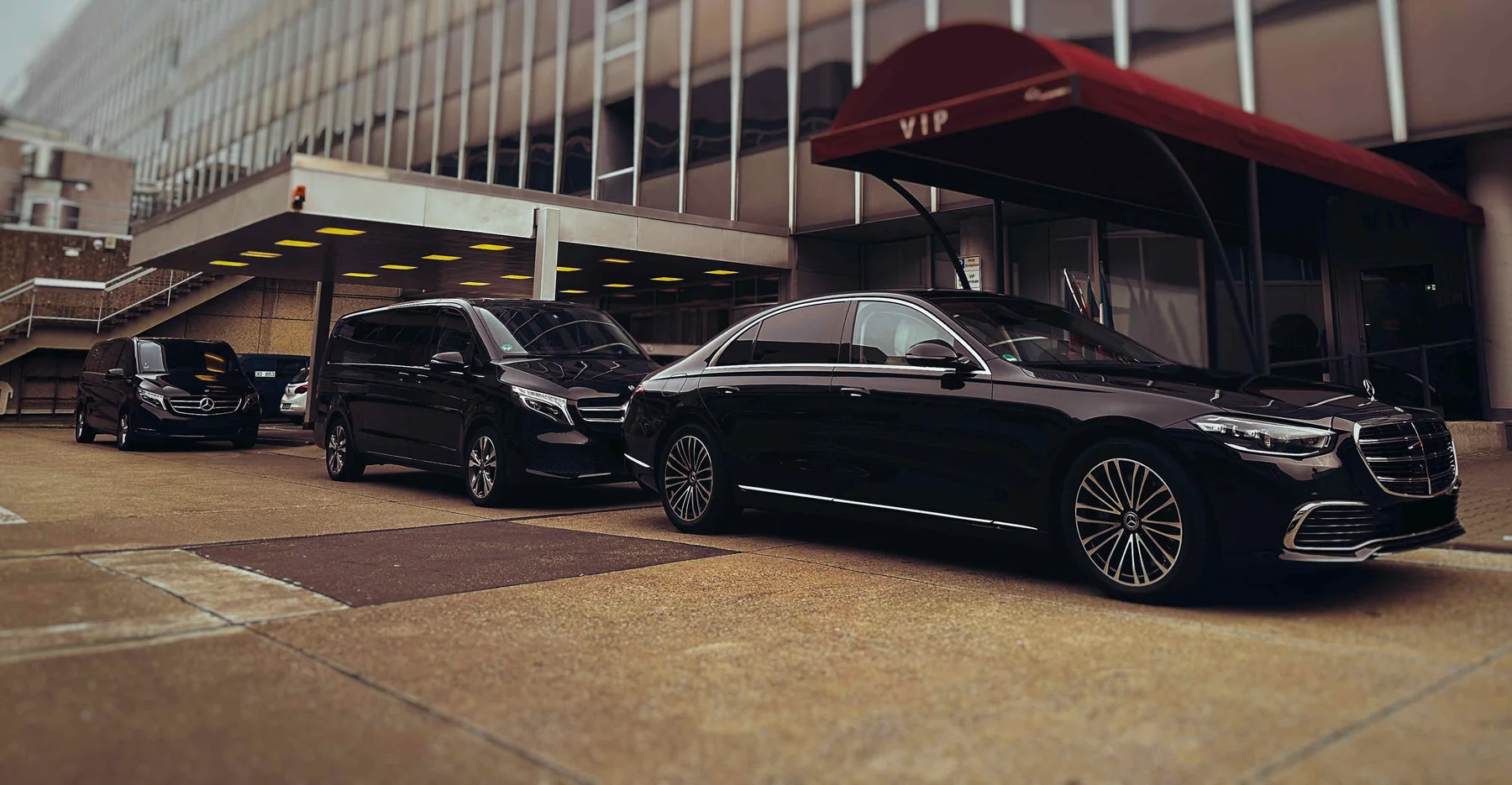 Mercedes S-Klasse, V-Klasse und Sprinter am VIP-Eingang einer Veranstaltungshalle