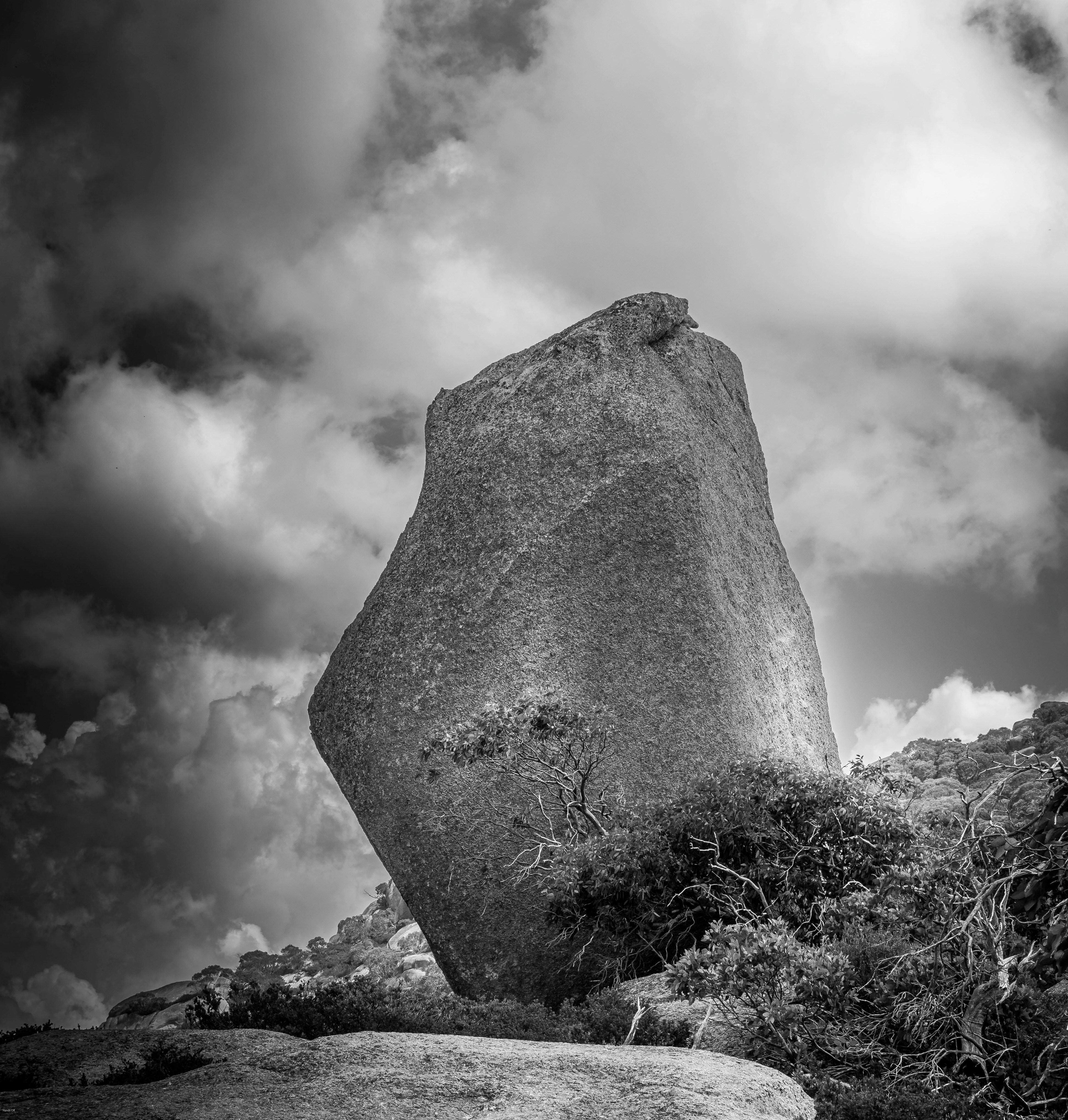 a large rock sitting on top of a lush green field