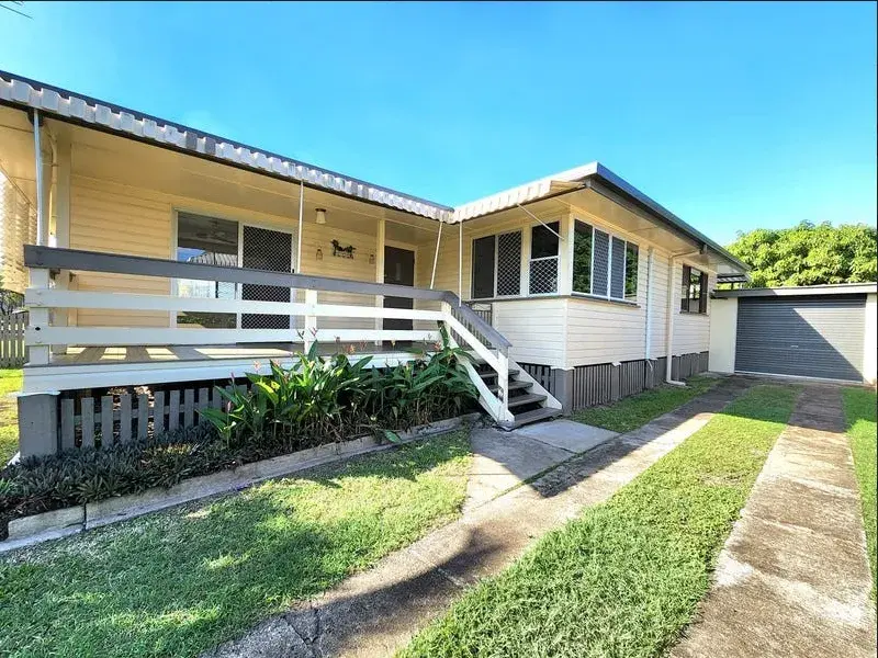 Yellow elevated house with deck and attached garage.
