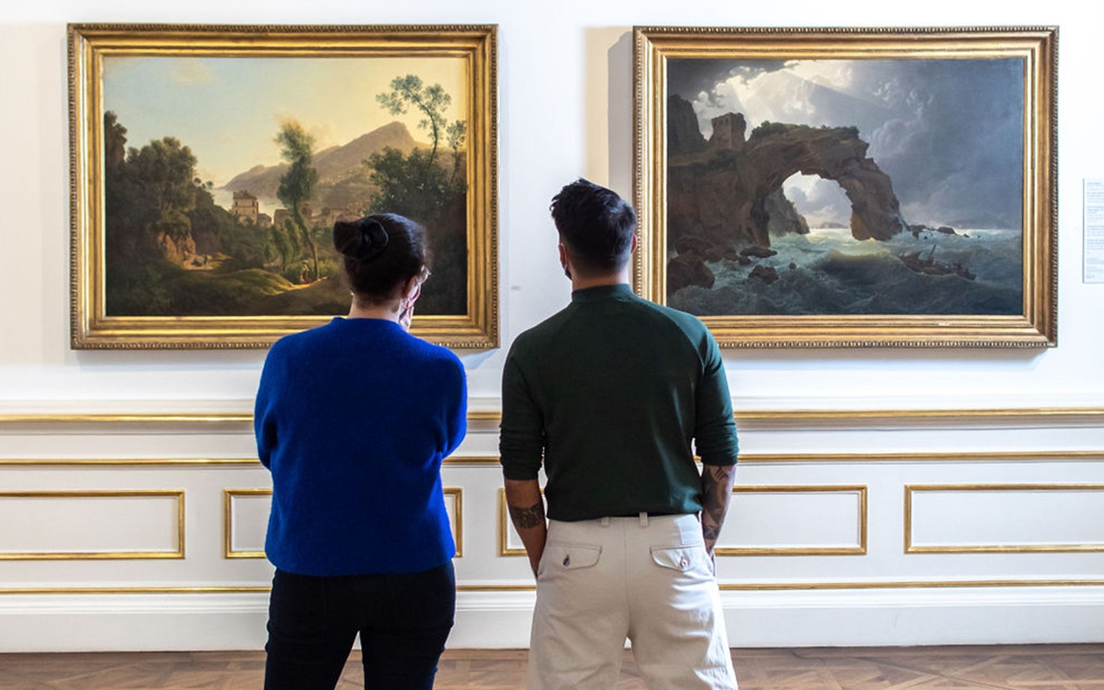Pengunjung melihat lukisan pemandangan di Istana Belvedere, Wina.