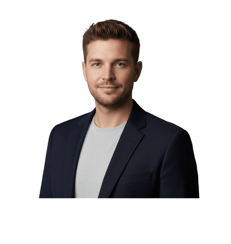 Smiling man with brown hair wearing a navy blazer and light gray shirt. He is looking at the camera.