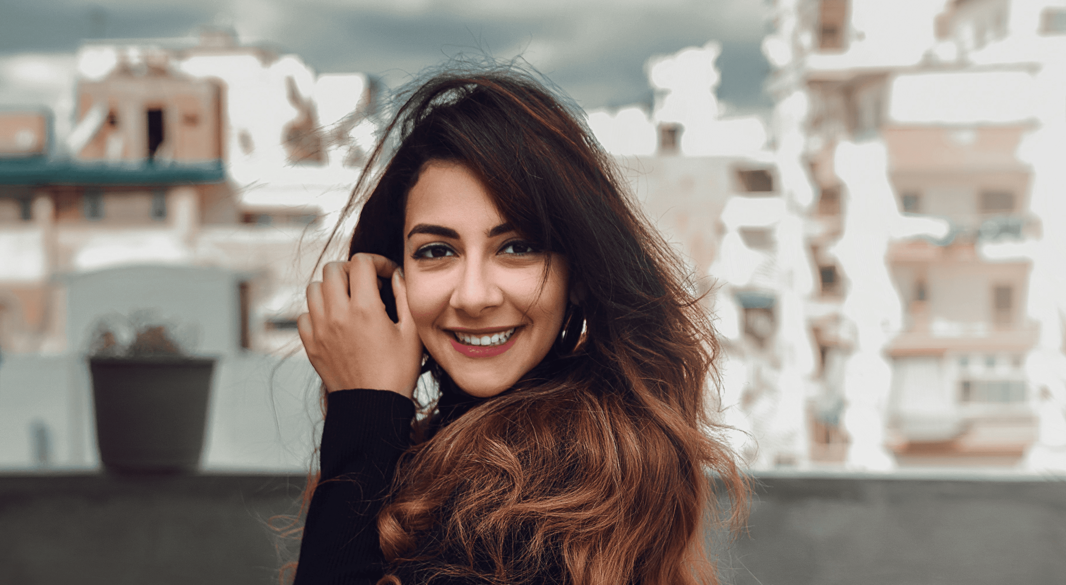 woman in black long sleeve shirt standing near red flowers during daytime