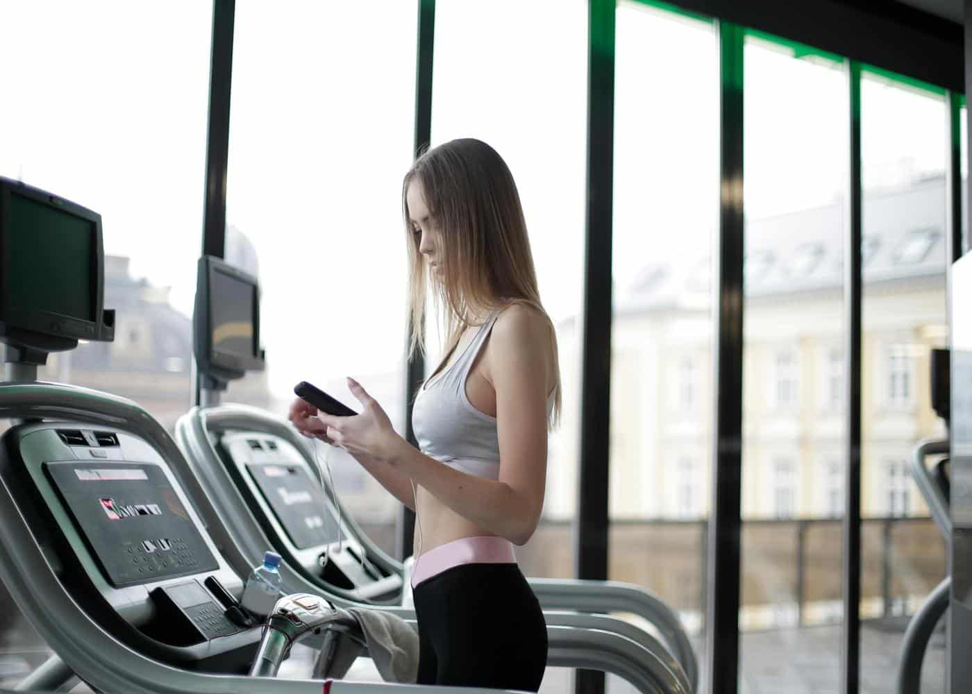 Woman on treadmill looking at phone