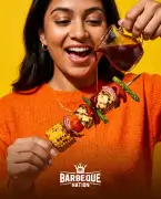 Person enjoying a fresh grilled skewer, Barbeque Nation food.