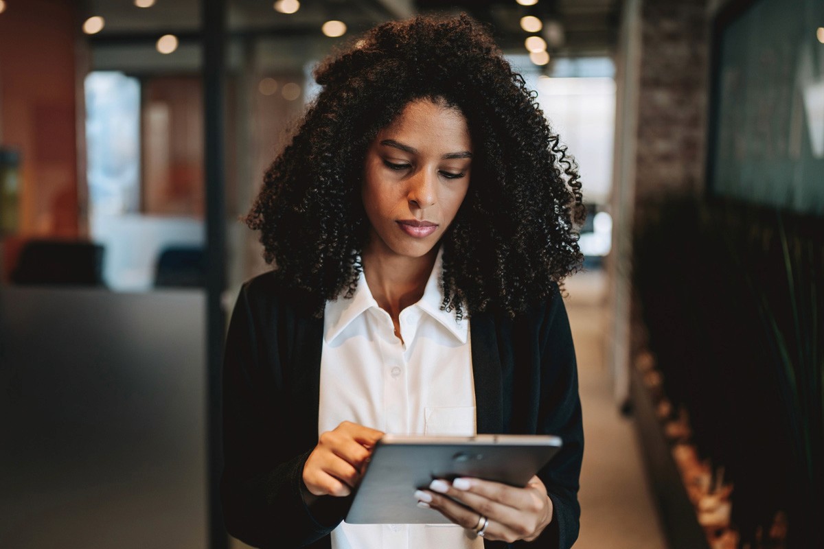 A woman holding a tablet computer in an office environment