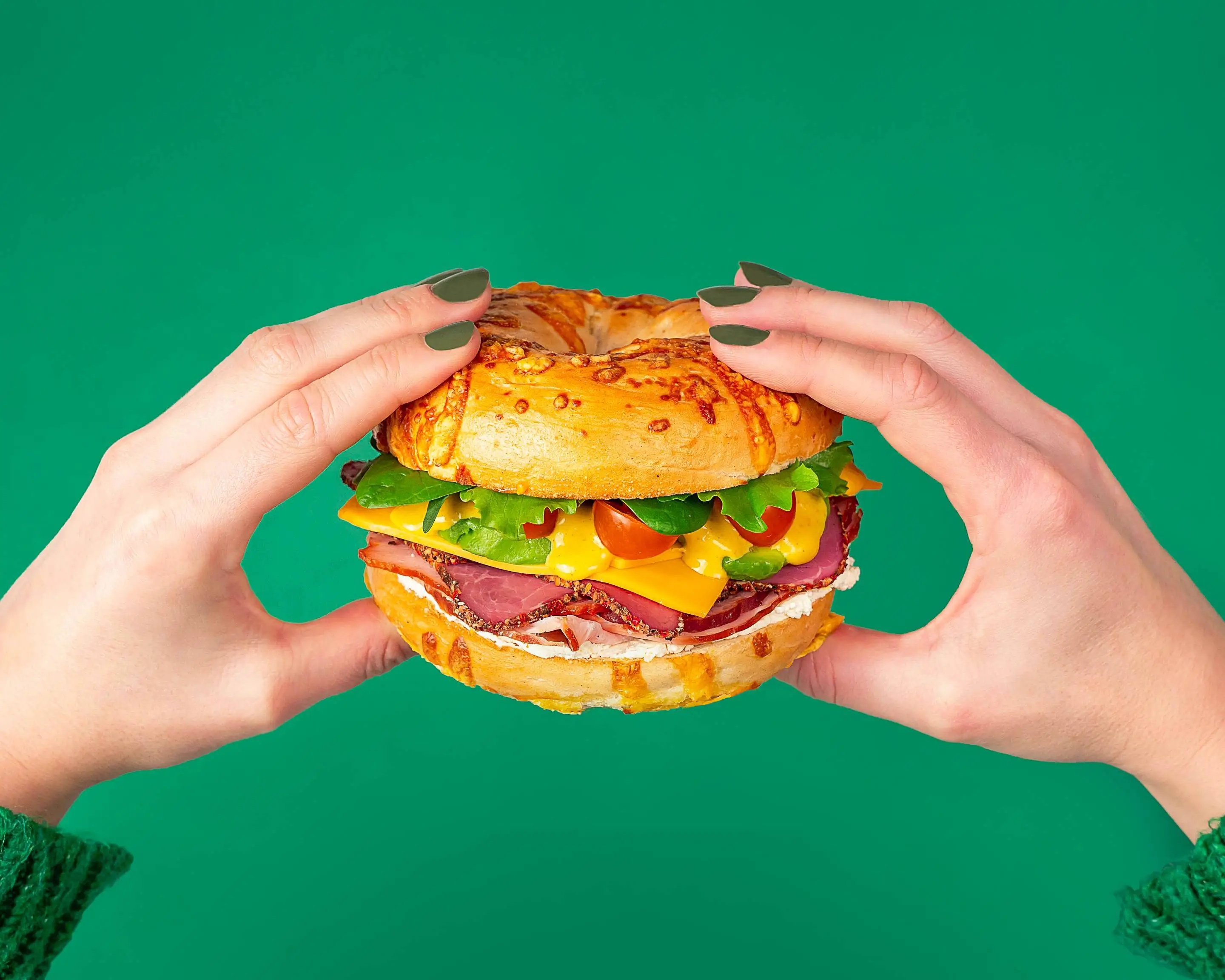 Burger appétissant tenu entre des mains