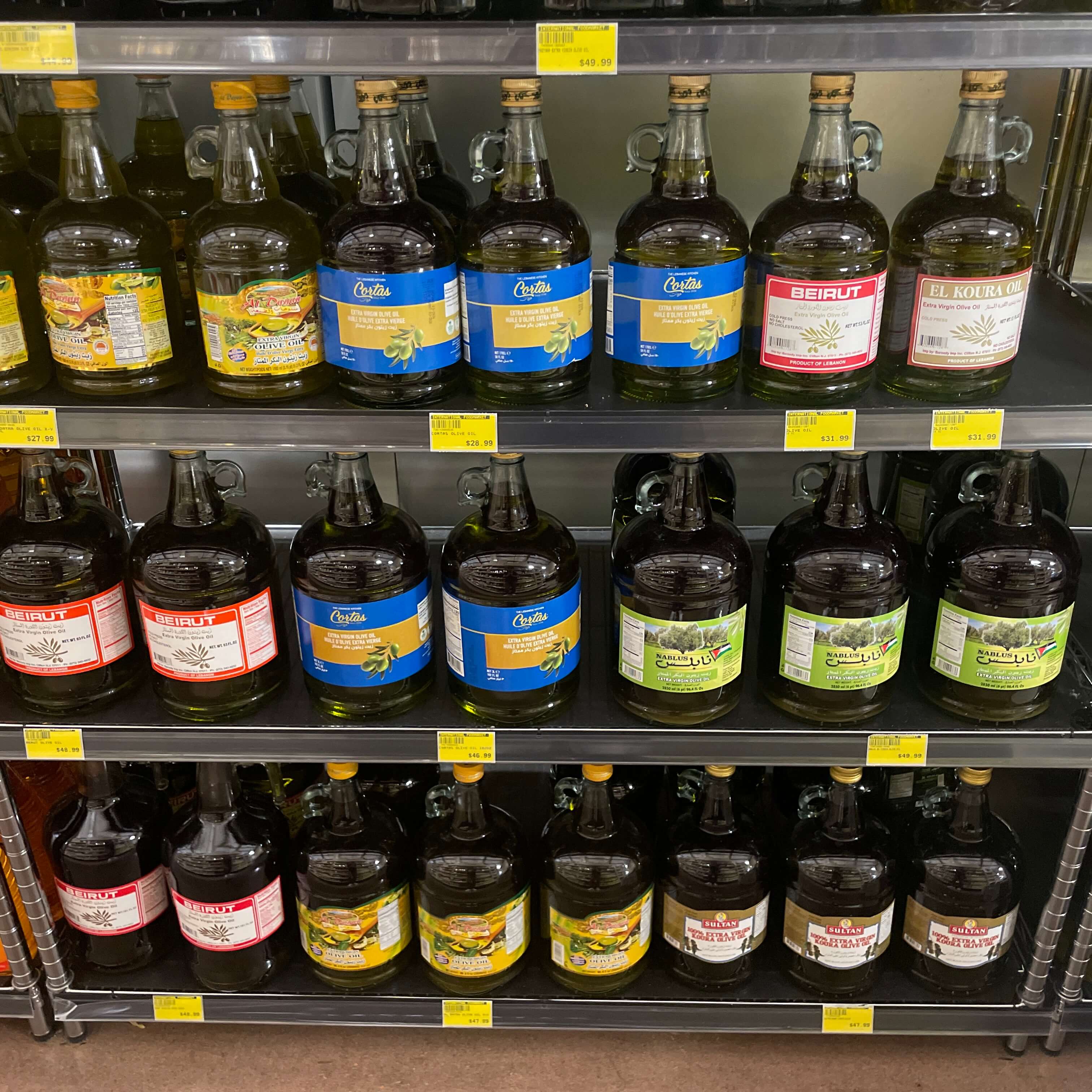 Assorted large containers of olive oil and specialty oils at International Food Market Orlando.