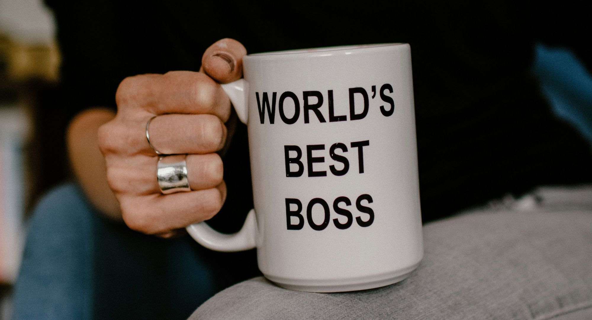 mão feminina segurando uma caneca escrita "world's best boss"