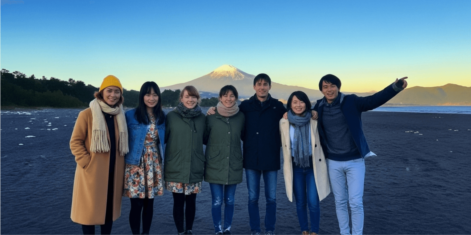 富士山を背景に友人たちが笑顔で並ぶ集合写真