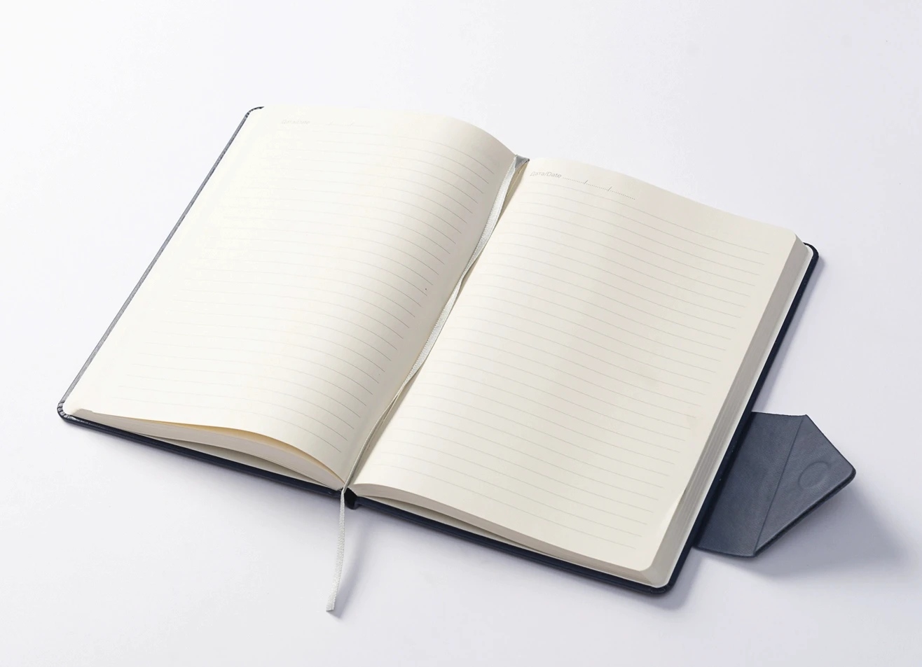 Open journal showing ruled ivory pages, ribbon bookmark, and back pocket