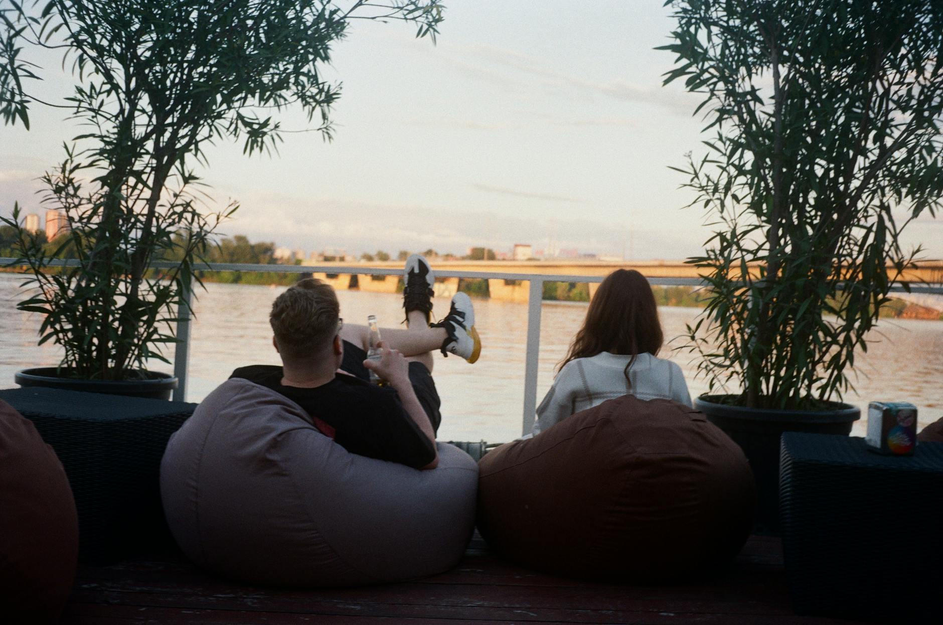 Elementary students sitting on colorful floor cushions and bean bags while reading books together in a learning space.
