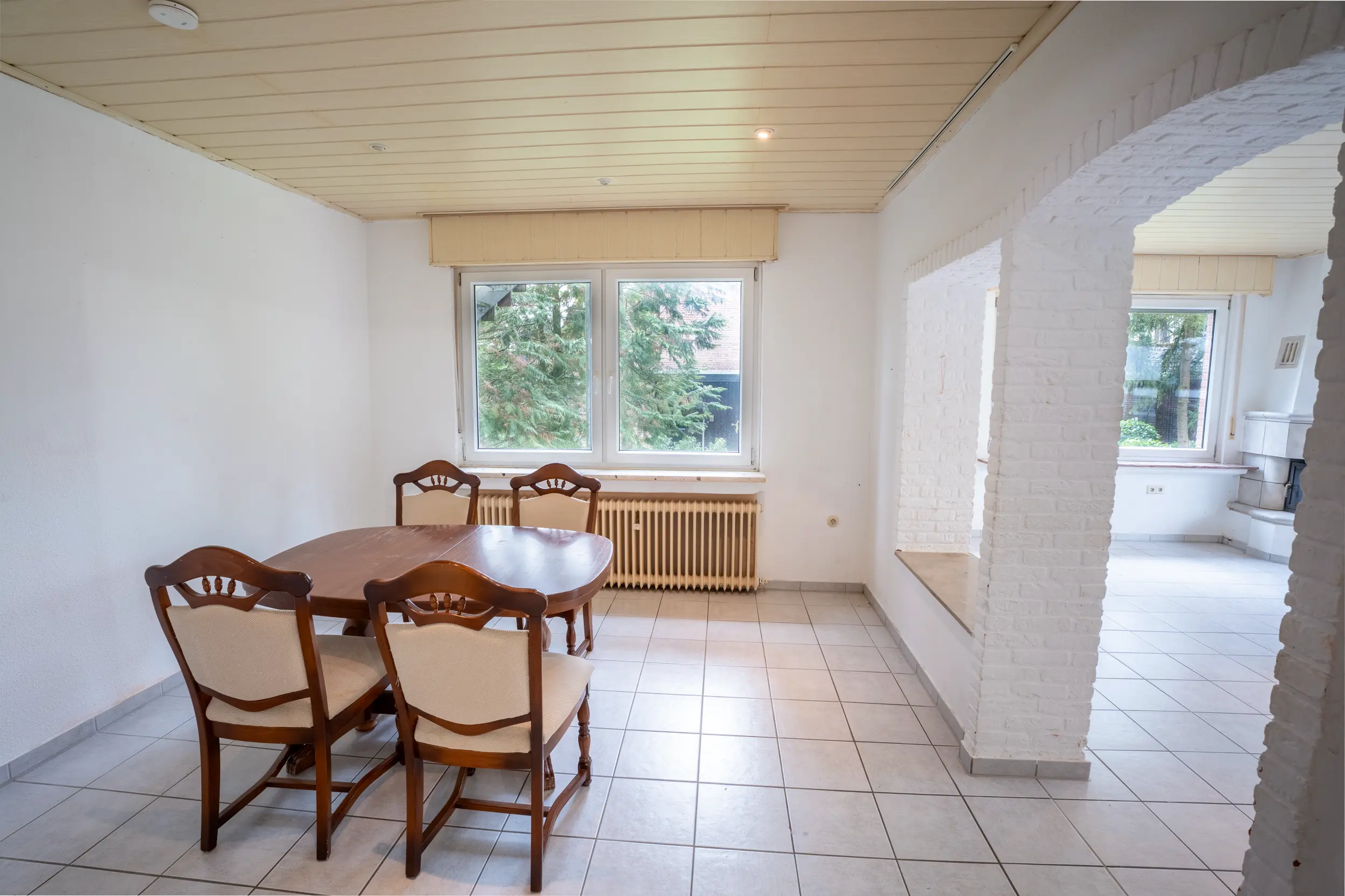 Heller Essbereich mit Fliesenboden, großem Fenster und offenem Übergang zum Wohnbereich im Einfamilienhaus in Gronau-Epe.