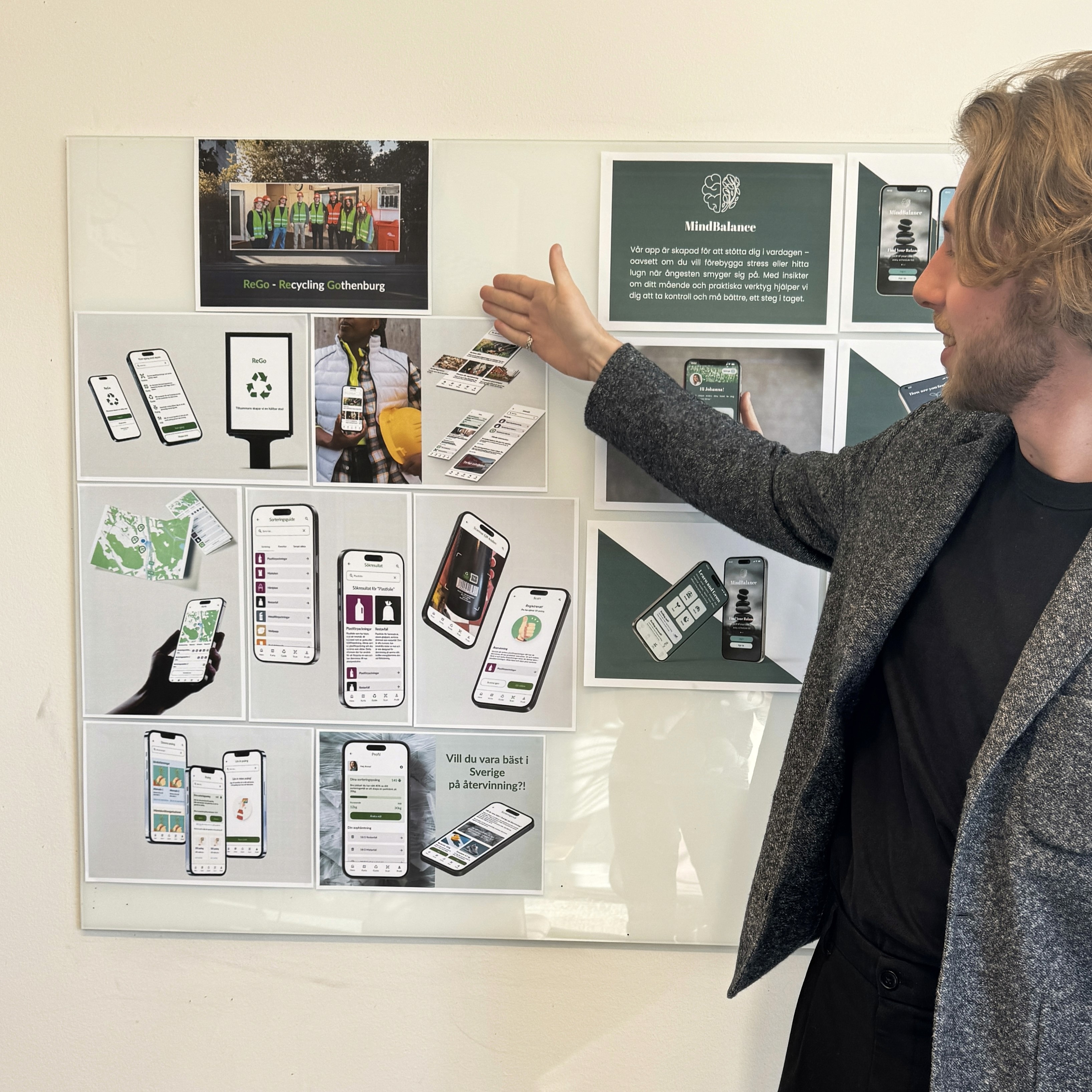 Lukas pointing at print of smartphone showing a finish app design.