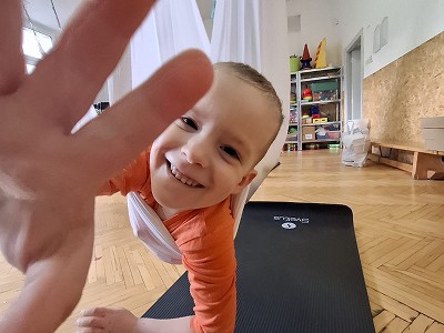 Usměvavý chlapec mávající do kamery při cvičení na podložce