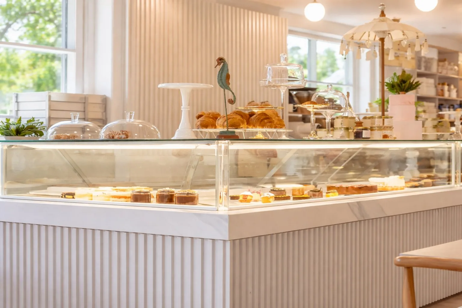 Aménagement intérieur d'un commerce – comptoir vitrine cannelé blanc, présentation de pâtisseries, espaces lumineux et optimisés, local professionnel à Bordeaux