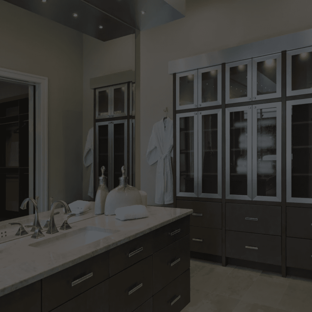Modern bathroom with dark wood cabinets, double vanity with vessel sinks, large mirror, and glass-paneled storage cabinets.