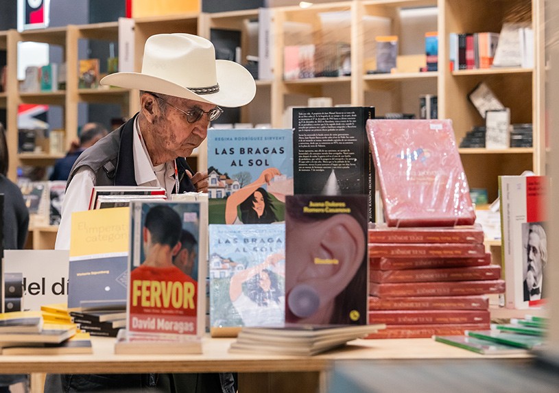 A visitor browsing books at the Guadalajara International Book Fair