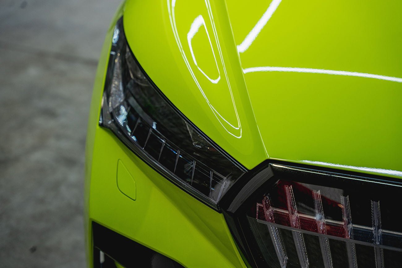 Élénkzöld, magasfényű színes karosszériavédő fóliával (PPF Wrap) bevont Skoda orr-része és emblémája. Tökéletes színváltás és kőfelverődés elleni védelem egyben a Nortek kivitelezésében.