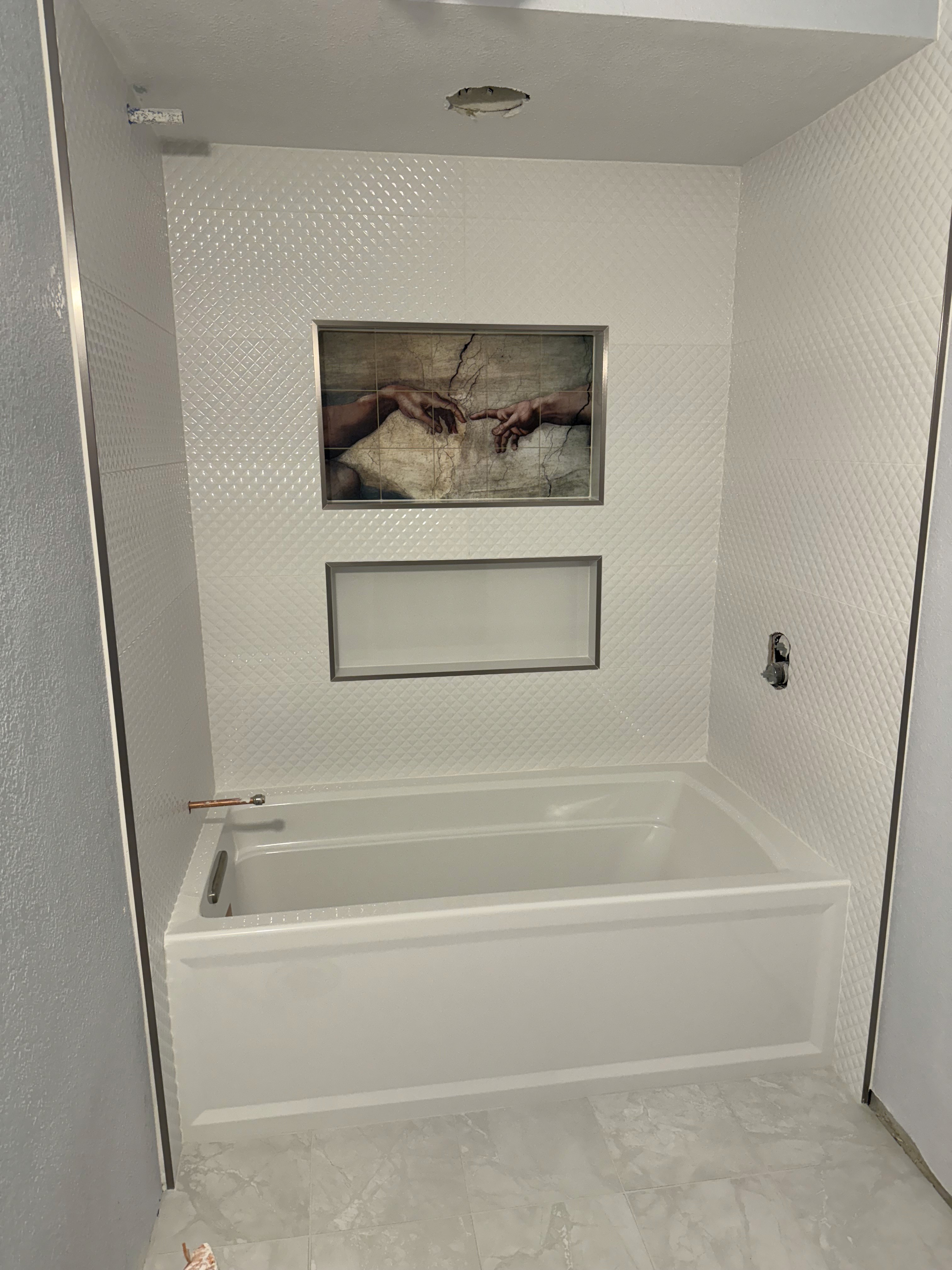 Luxurious bathroom vanity area with a dramatic wall featuring large format natural stone tiles in varying earthy tones and complex veining, serving as a striking backsplash above a double sink vanity.