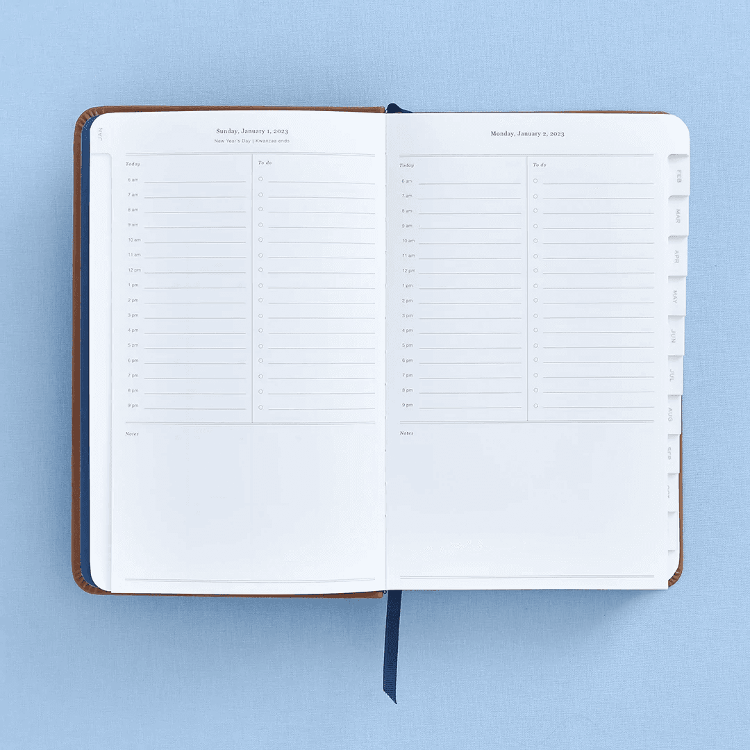 daily planner open to "sunday january 1, 2023" with a daily schedule, a to do list, and a notes section