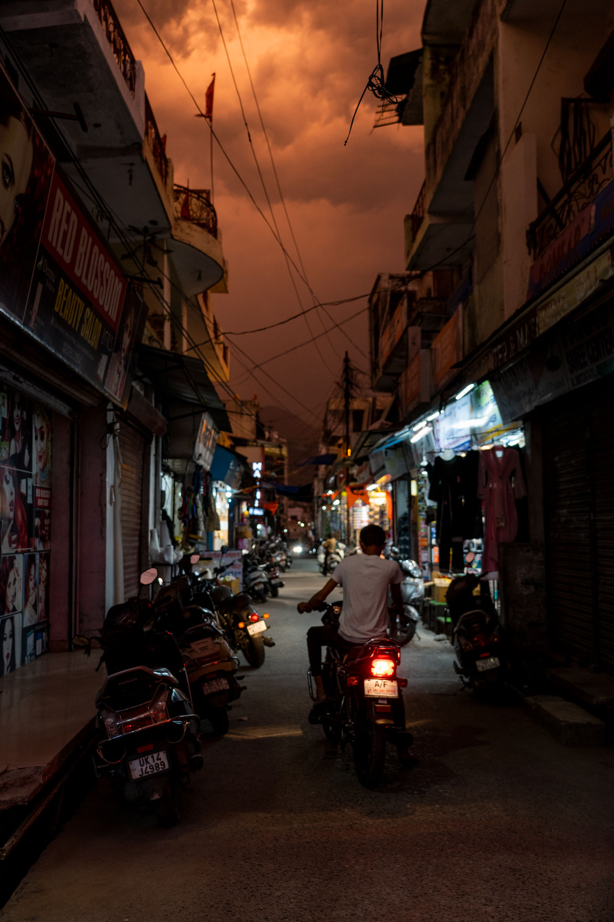 View of a street in the city of Rishikesh during an orange sky. India