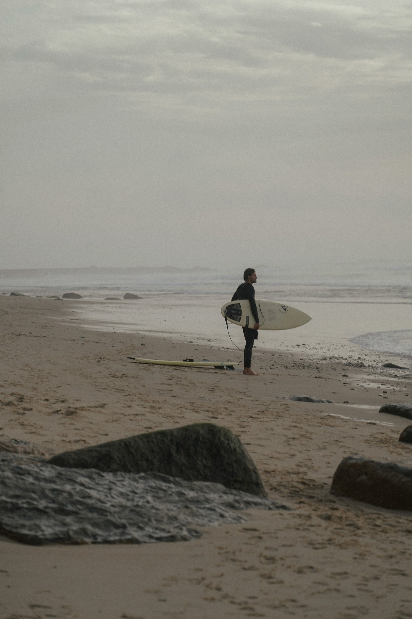 Hombre en la playa con tabla de surf