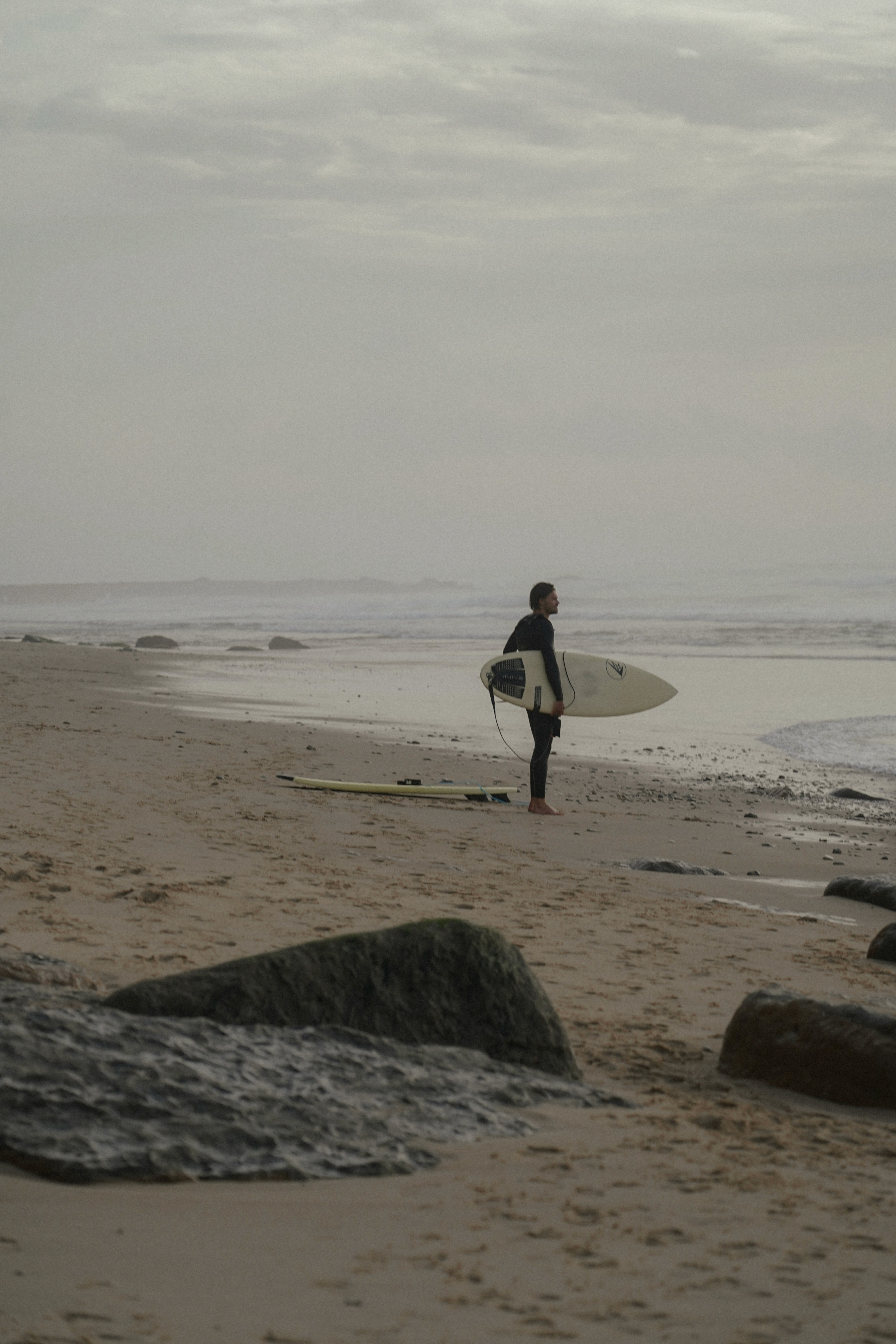 Hombre en la playa con tabla de surf
