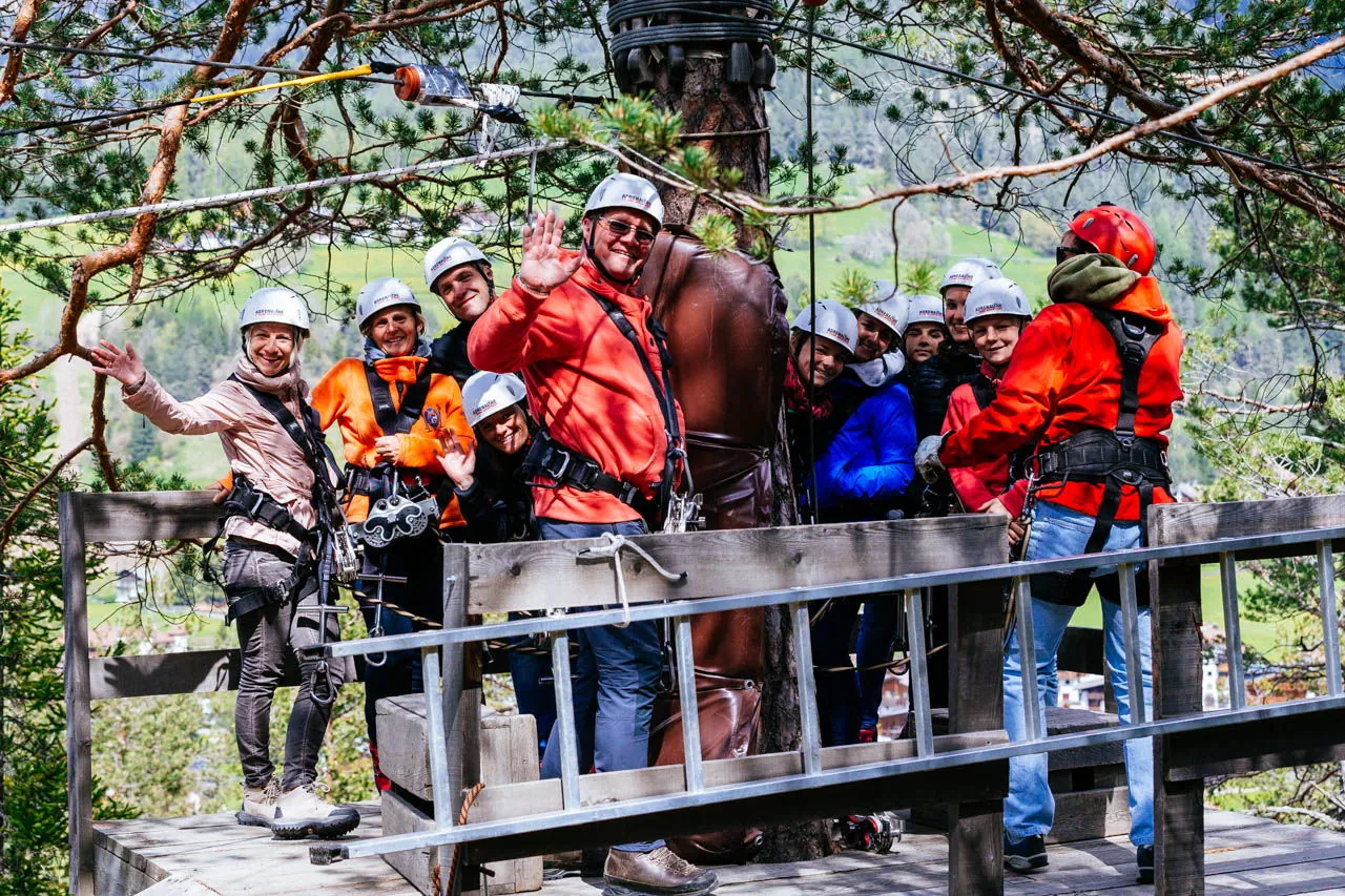 Volo sulla zipline sopra il bosco con nuvole bianche