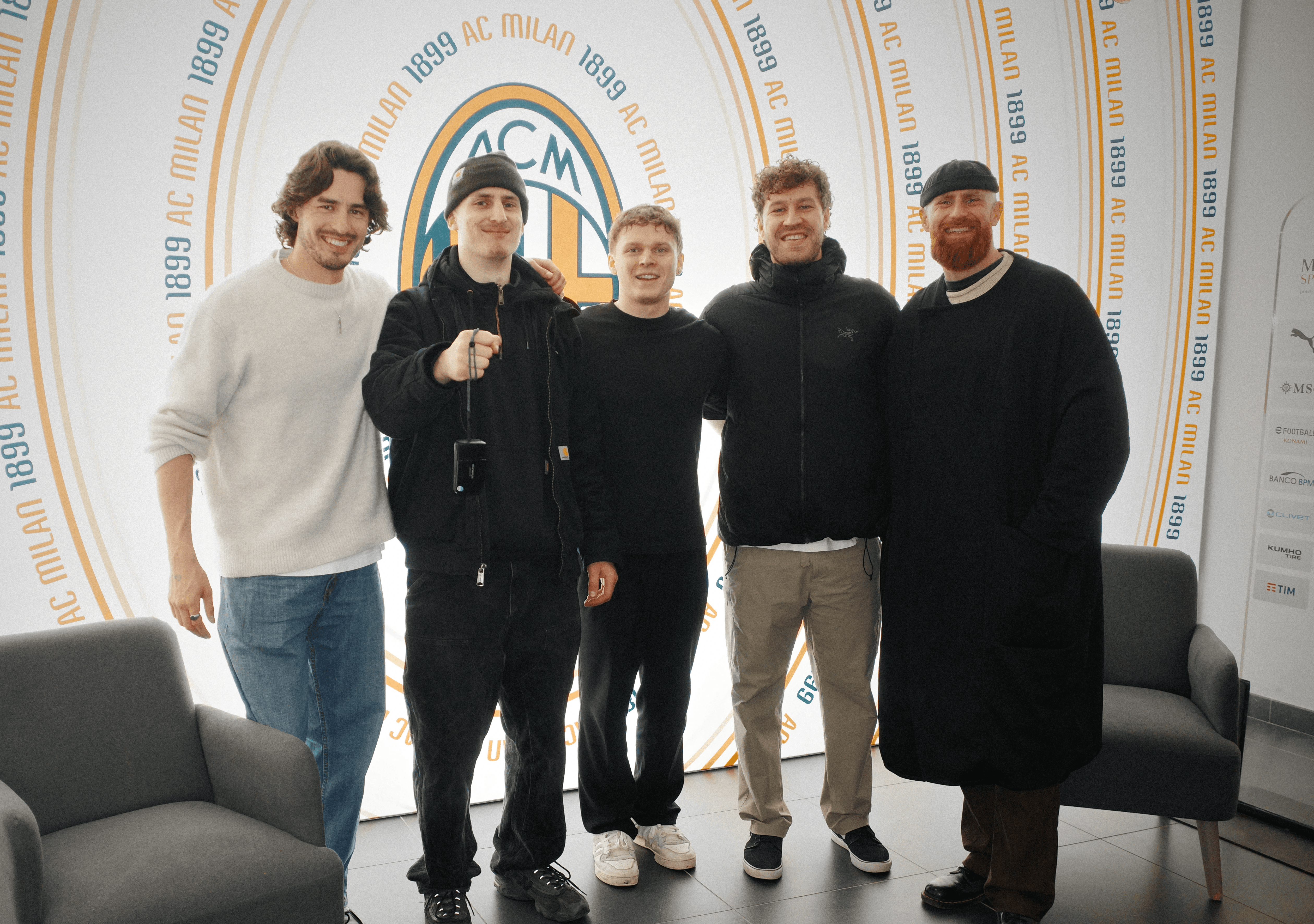 GRIT Sports team photo infront of the AC Milan Logo after a partnership video and social media content production.