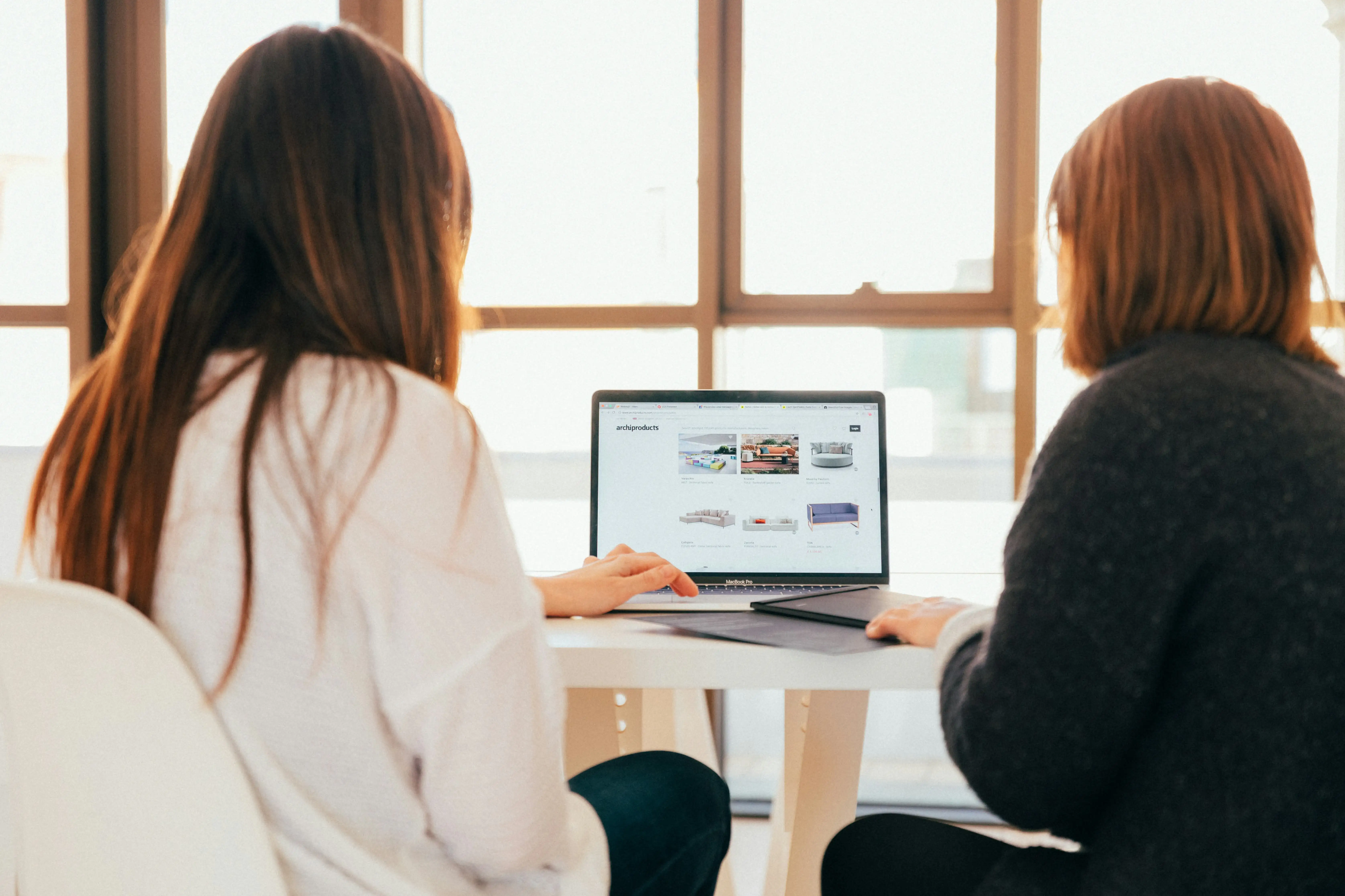 Two people looking into a computes, transitioning their business into digital experience