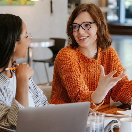 Women discussing data migration in office