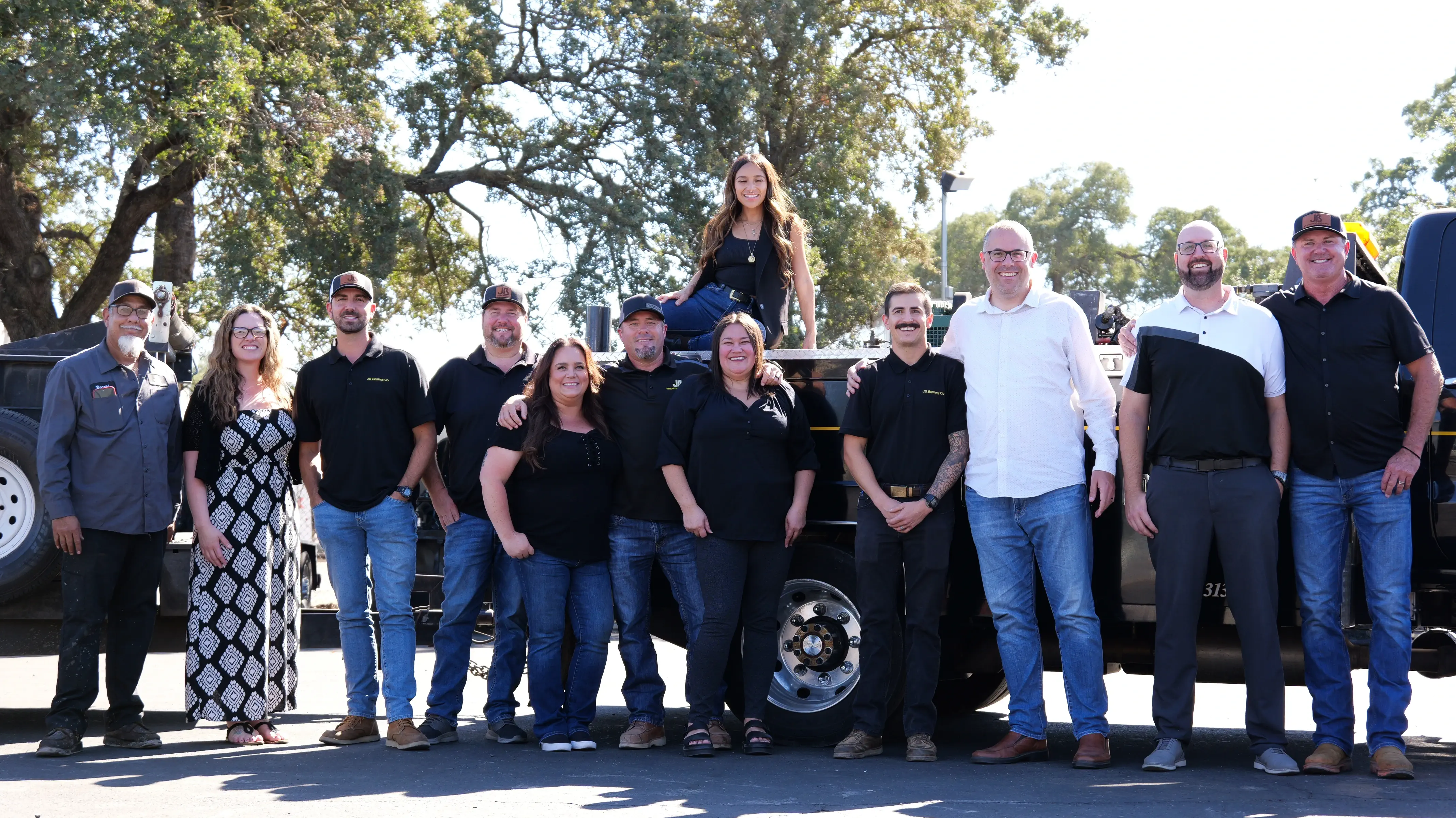 Group photo of entire office team in front of truck